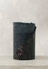 Image of navy leather wrapped vase stitched with charcoal leather cord on a stone table.